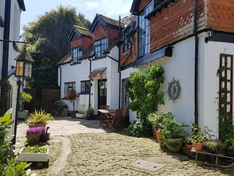 The Coach House exterior with cobbled courtyard and outdoor dining set.