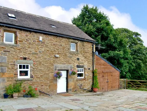 The Loft converted stone stable block with hanging baskets, skylights, and a paved courtyard