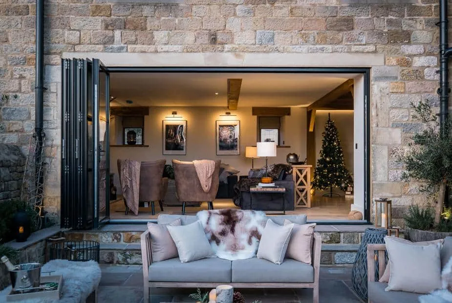 Stone exterior with open doors revealing The Malt Kiln living room and a Christmas tree inside