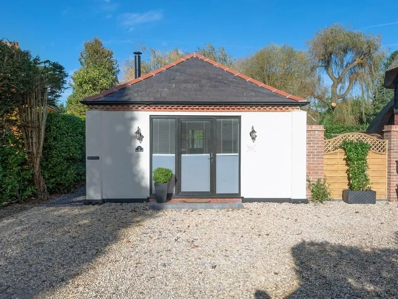 The Old Meeting Hall with gravel drive and central glass door entrance.