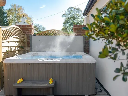 Cottage garden with outdoor hot tub and steam rising