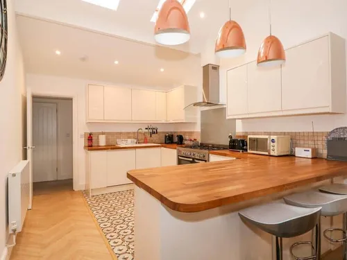Kitchen with wooden worktops and breakfast bar with stools