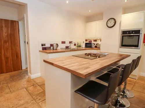 Kitchen with island hob and bar stools