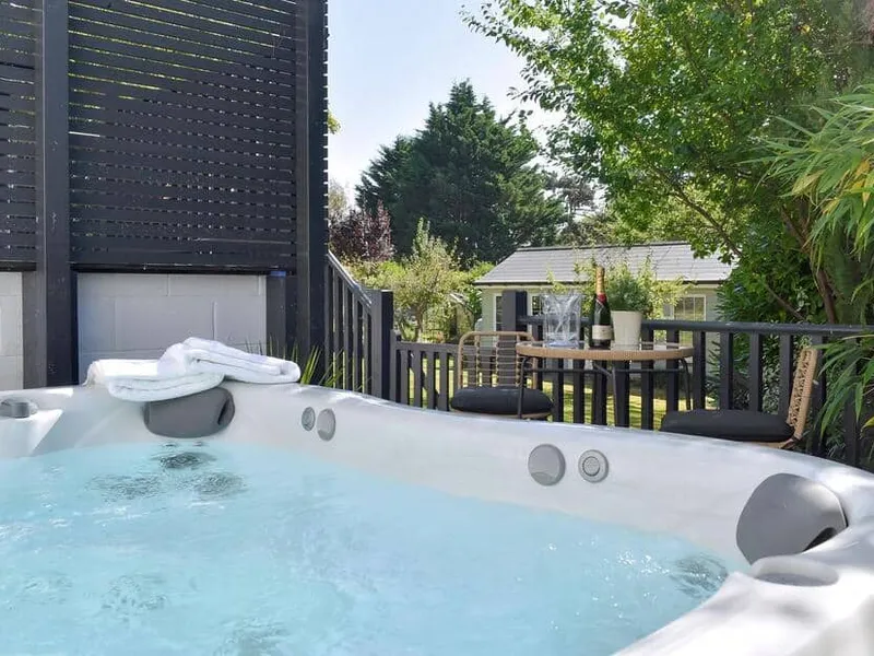 Outdoor hot tub and patio seating at The White House Retreat, with garden view