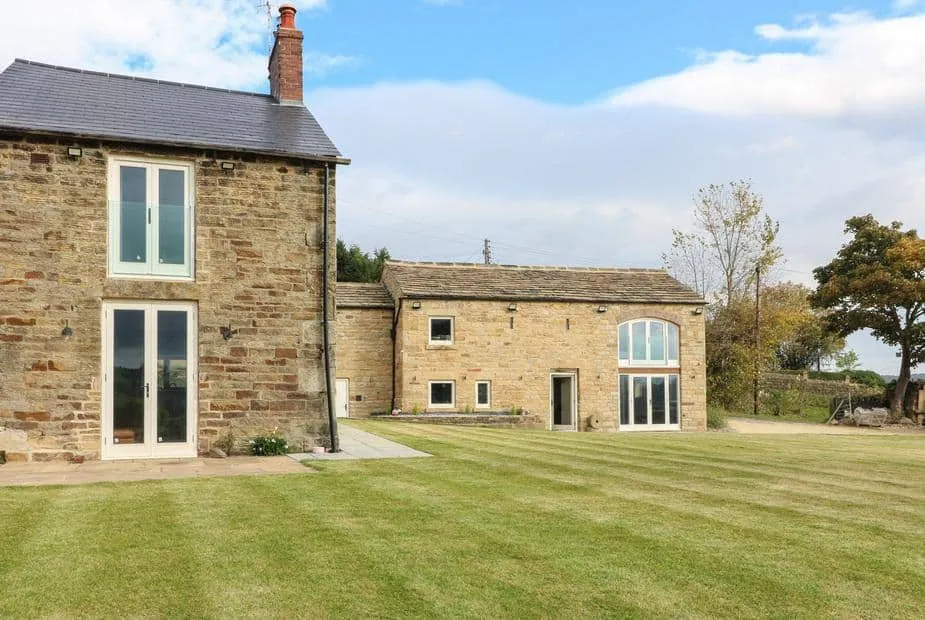 Top Hill Farm Cottage with large stone exterior and spacious lawn