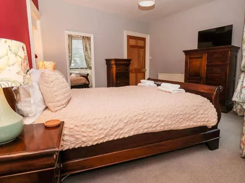 Cottage bedroom with wooden sleigh bed and chest of drawers