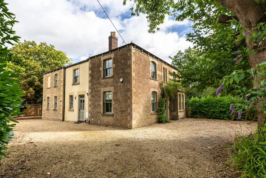 Vallis Oak Villa stone cottage with gravel driveway and mature trees on the edge of Frome