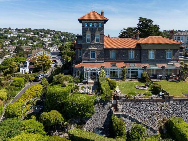 Vane Hall with terraced gardens and conservatory overlooking the hillside town.