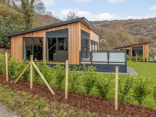 Wedmore Premier cedar-clad lodge with large windows and wooded Mendip hillside behind