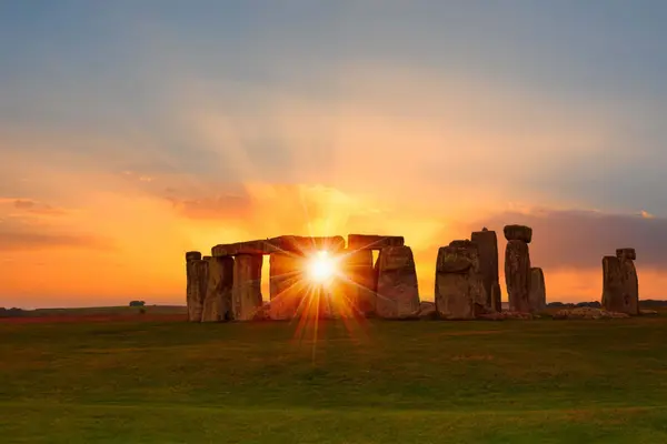 Sunburst shining through the ancient standing stones of Stonehenge in Wiltshire.