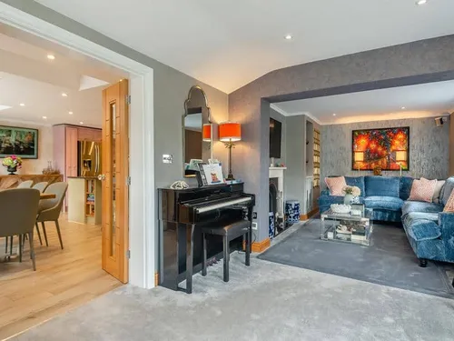 Cottage living room with piano and blue corner sofa