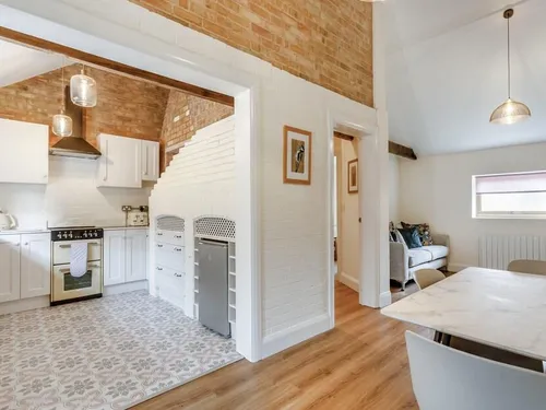 Kitchen with range cooker and open plan dining area with table and chairs
