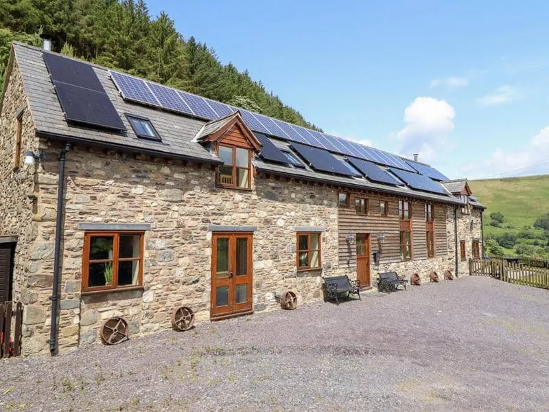 Ysgubor Pwlliago stone cottage exterior with solar panels and countryside views