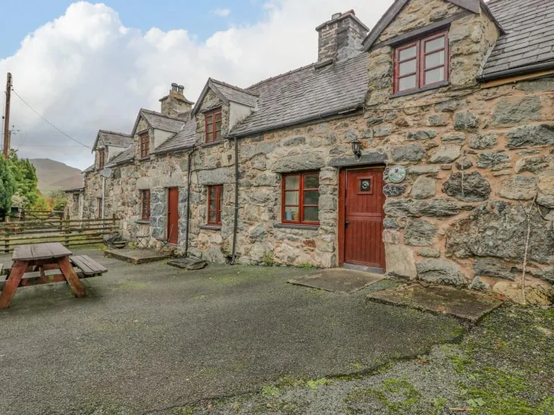 Stone-fronted Ysgubor with picnic bench on paved patio area