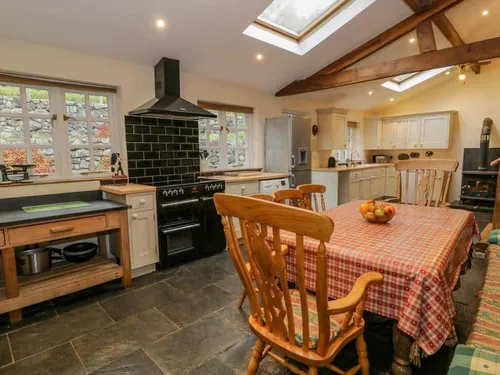 Cottage kitchen with dining table, range cooker and exposed wooden beams