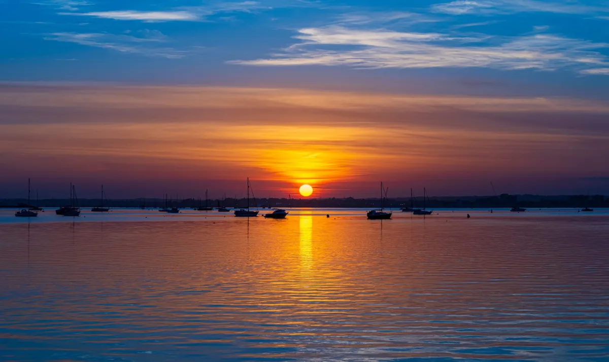 Luxury boats moored at Sandbanks during a golden sunset near Bournemouth.